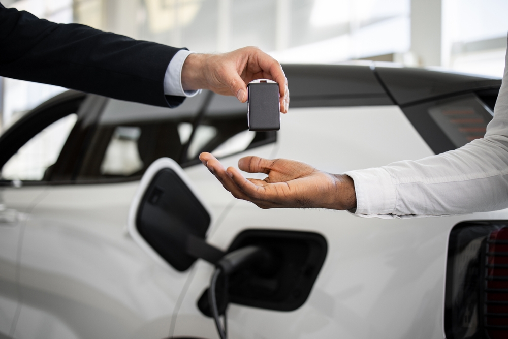 Dealer,Handing,Car,Key,To,Businessman,With,Electric,Suv,In